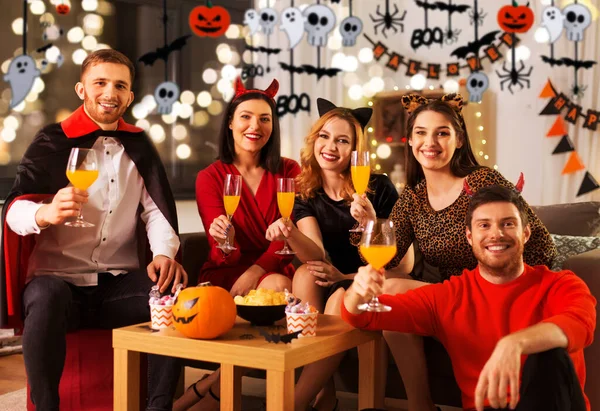 Amigos felizes em trajes de Halloween na festa em casa — Fotografia de Stock