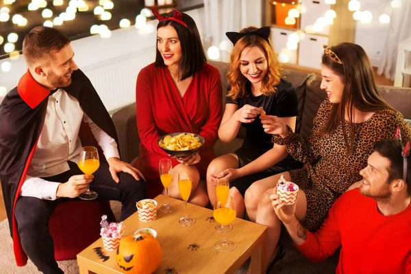 Glada vänner i halloween kostymer på hemmafest — Stockfoto