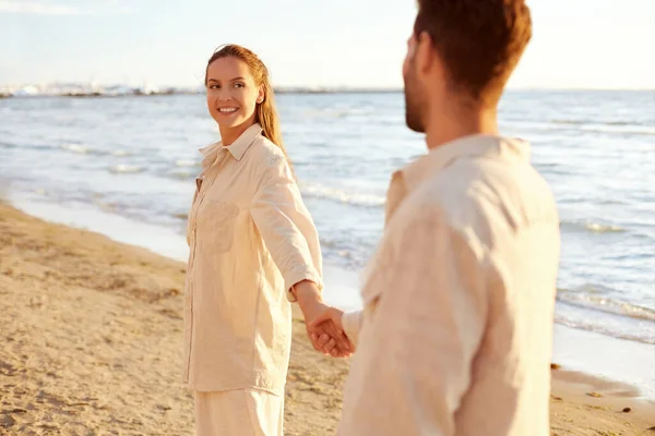 Casal feliz de mãos dadas na praia de verão — Fotografia de Stock