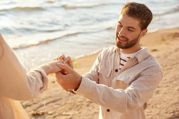 Uomo con anello che fa proposta alla donna sulla spiaggia — Foto Stock