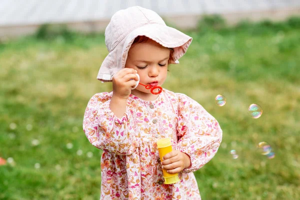 Gelukkig baby meisje blazen zeepbellen in de zomer — Stockfoto