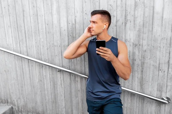 Young athlete man with earphones and smartphone — Stock Photo, Image