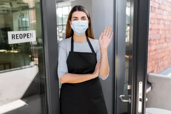 Woman in mask with reopen banner on door glass — Stock Photo, Image