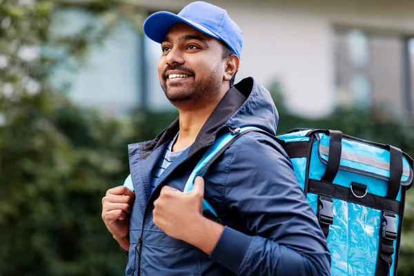 Glücklich lächelnder indischer Zusteller mit Tasche in der Stadt — Stockfoto