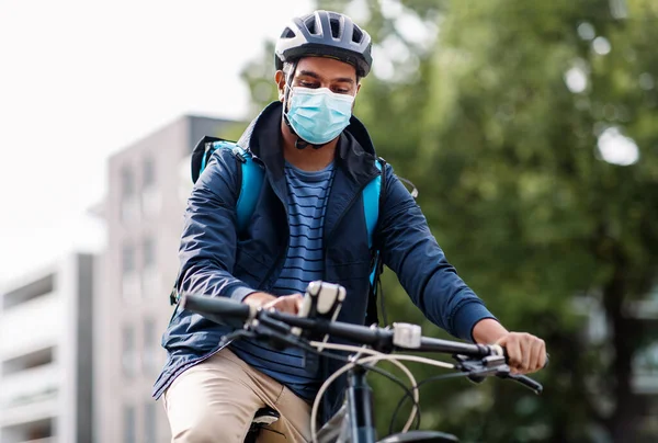 Hombre de entrega en máscara con bicicleta de montar smatphone — Foto de Stock