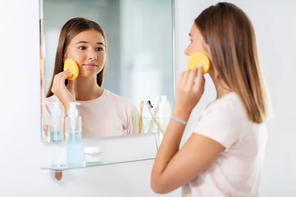 Teenager-Mädchen putzt Gesicht mit Schwamm im Bad — Stockfoto