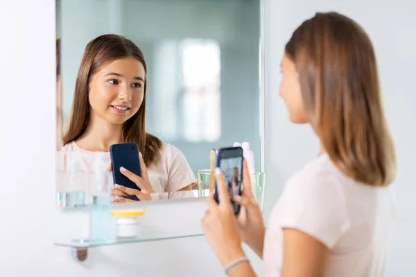 Adolescente chica mirando en espejo y tomando selfie — Foto de Stock