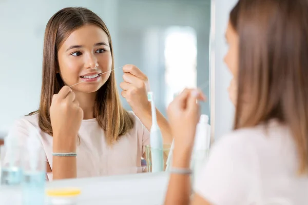 Adolescente com fio dental limpeza dentes no banheiro — Fotografia de Stock