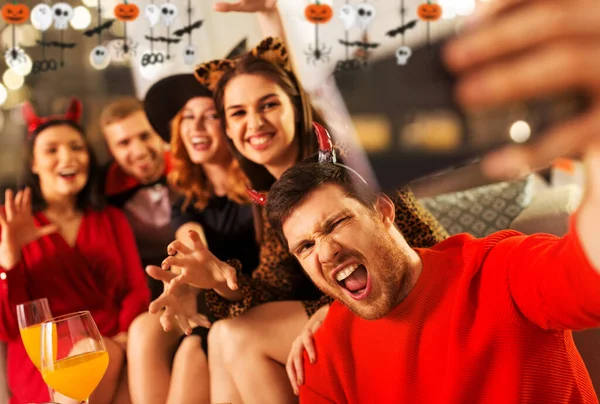 Gelukkig vrienden in halloween kostuums nemen selfie — Stockfoto