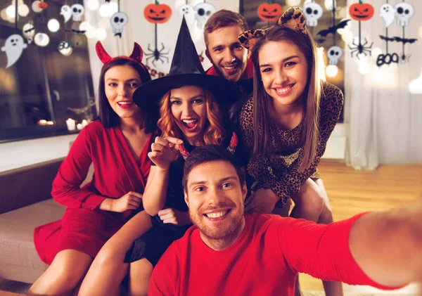 Glada vänner i halloween kostymer tar selfie — Stockfoto