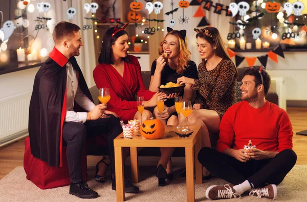 Amis heureux en costumes d'Halloween à la fête à la maison — Photo