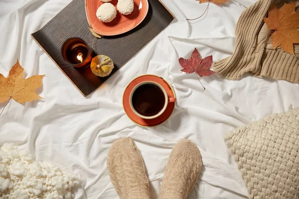 Xícara de café, folhas de outono e vela na cama — Fotografia de Stock