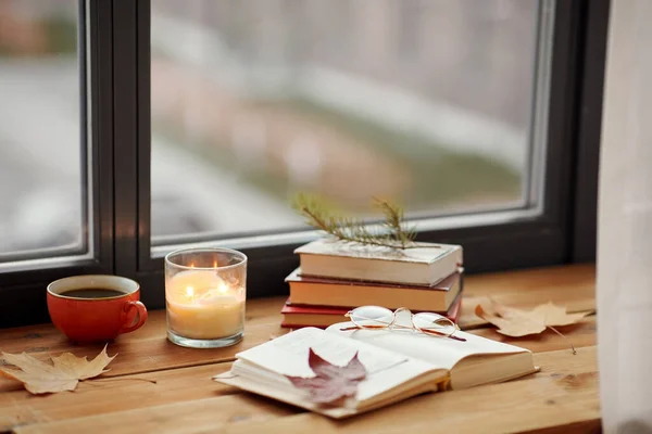 Libro, café y vela en el alféizar de la ventana en otoño — Foto de Stock