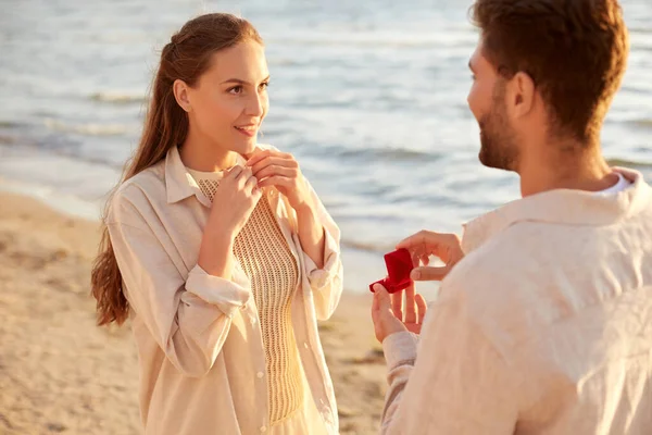 Homem com anel fazendo proposta para mulher na praia — Fotografia de Stock