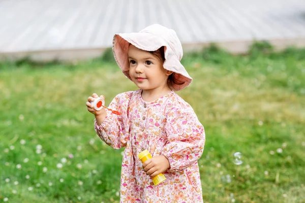 Menina feliz soprando bolhas de sabão no verão — Fotografia de Stock