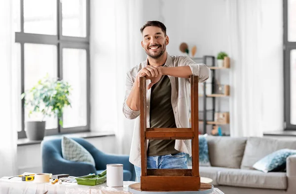 Hombre feliz renovando la vieja mesa de madera en casa — Foto de Stock