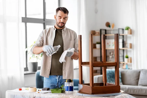 Homem aplicando solvente para pano para limpar mesa velha — Fotografia de Stock