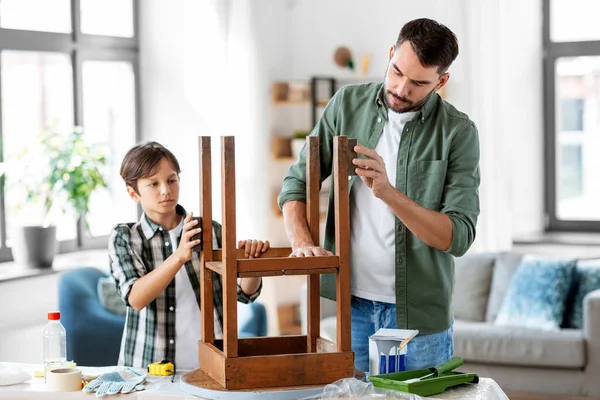Vader en zoon schuren oude tafel met spons — Stockfoto