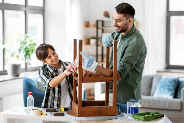 Vader en zoon schoonmaken oude tafel met weefsel — Stockfoto