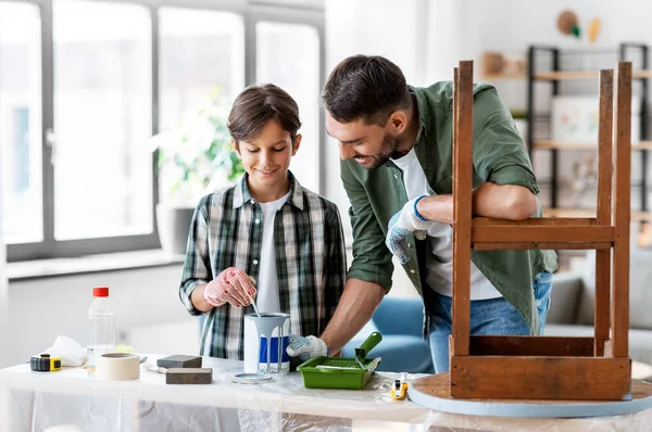 Pai e filho mexendo tinta de cor cinza em casa — Fotografia de Stock
