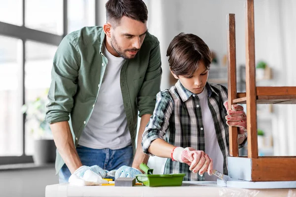 Padre e hijo pintando mesa vieja en color gris —  Fotos de Stock