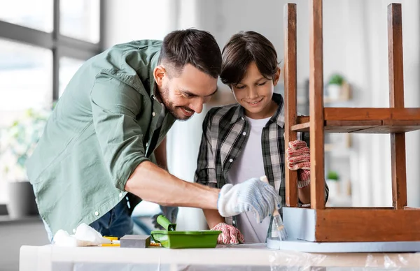 Padre e hijo pintando mesa vieja en color gris —  Fotos de Stock