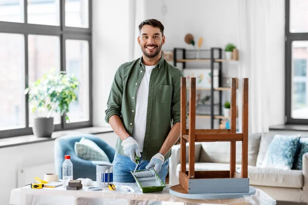 Чоловік малює старий стіл в сірому кольорі вдома — стокове фото