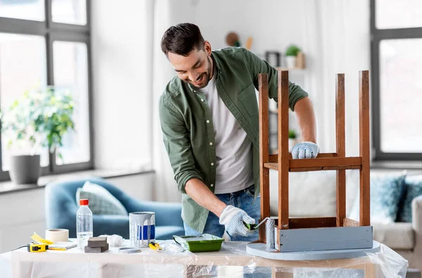 Mężczyzna malując stary stół w szarym kolorze w domu — Zdjęcie stockowe