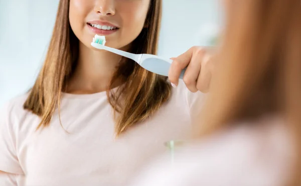 Adolescente chica con cepillo de dientes eléctrico cepillado dientes — Foto de Stock