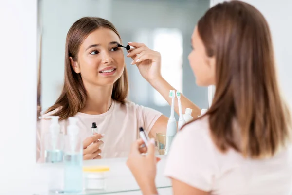 Adolescente aplicando rímel no banheiro — Fotografia de Stock