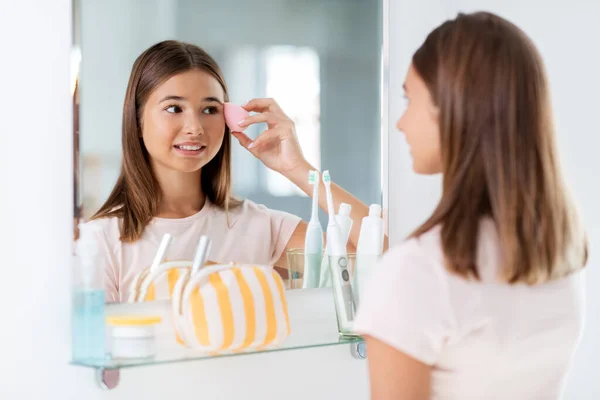 Adolescente aplicando fundação para enfrentar — Fotografia de Stock