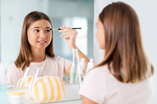 Adolescent fille application ombre à paupières à salle de bain — Photo