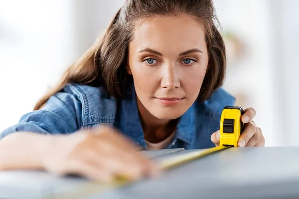 Woman with ruler measuring table for renovation — Stock Photo, Image