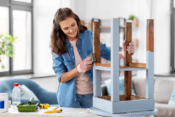 Woman sanding old round wooden table with sponge — Stock Photo, Image