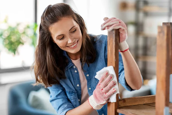 Žena čištění starého stolu povrch s tkání — Stock fotografie