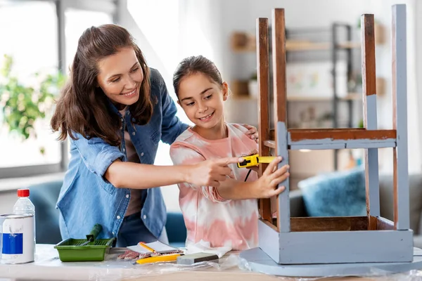 Mãe e filha com régua medindo mesa velha — Fotografia de Stock