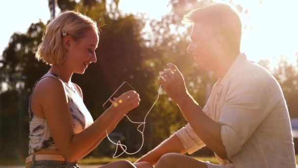 Feliz pareja con smartphone y auriculares en la ciudad — Vídeo de stock