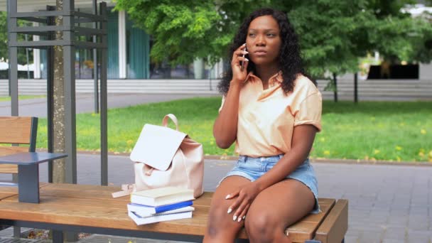 Afrikaans student meisje bellen op smartphone in de stad — Stockvideo