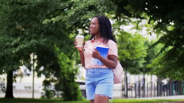 Afrikanska student flicka med kaffe och boka i staden — Stockvideo
