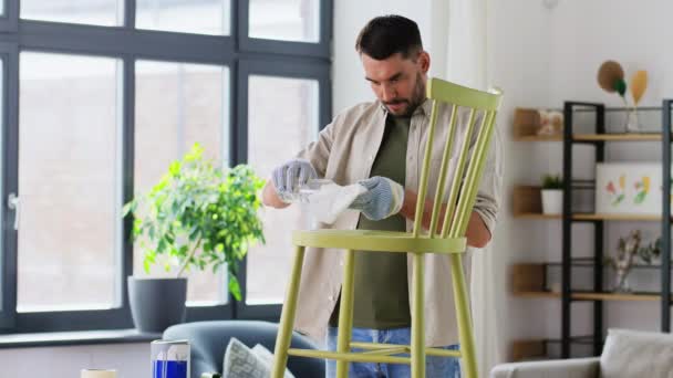 古い椅子をこすったり掃除したりするのに溶剤を使う男 — ストック動画