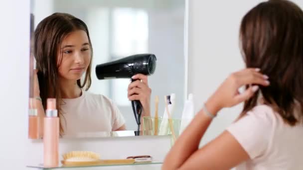 Nastolatka dziewczyna z suszarką do włosów w łazience — Wideo stockowe