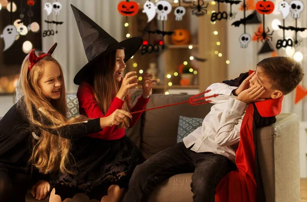 Ungar i halloween kostymer leker hemma — Stockfoto