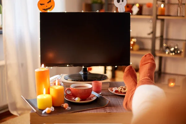 Joven mujer viendo tv en casa en halloween — Foto de Stock