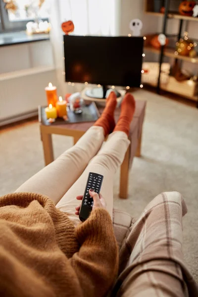 Cadılar Bayramı 'nda evde televizyon izleyen genç bir kadın. — Stok fotoğraf