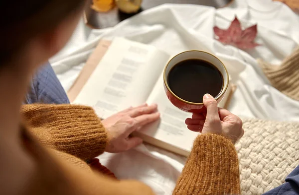 Mulher bebendo café e lendo livro no outono — Fotografia de Stock