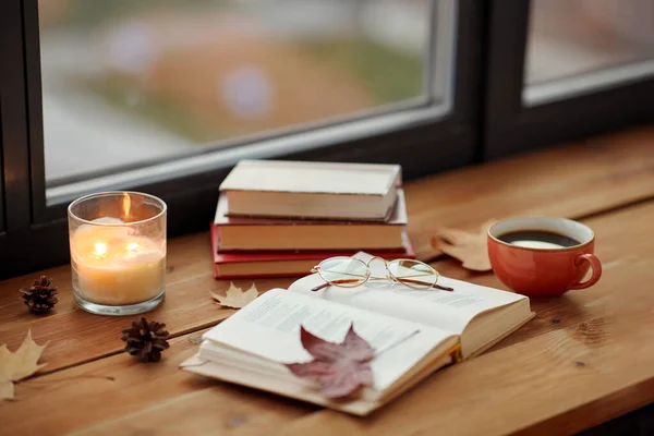 Book, coffee and candle on window sill in autumn — Stock Photo, Image