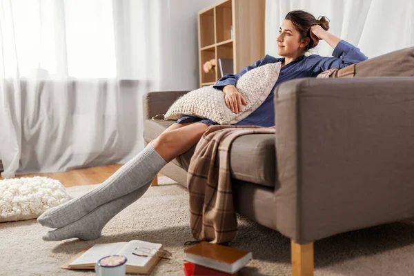 Mujer con almohada y libros en el suelo en casa — Foto de Stock