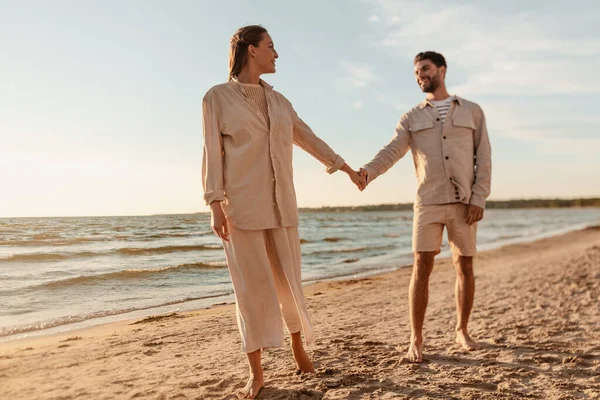 Boldog pár kéz a kézben a nyári strandon — Stock Fotó