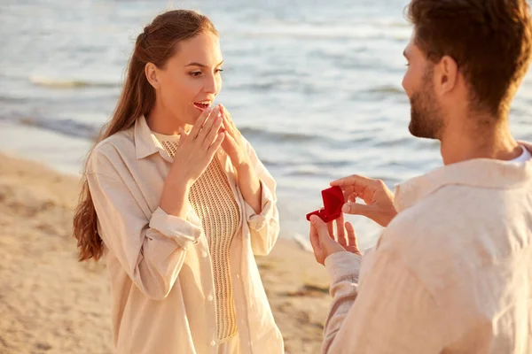 Homem com anel fazendo proposta para mulher na praia — Fotografia de Stock