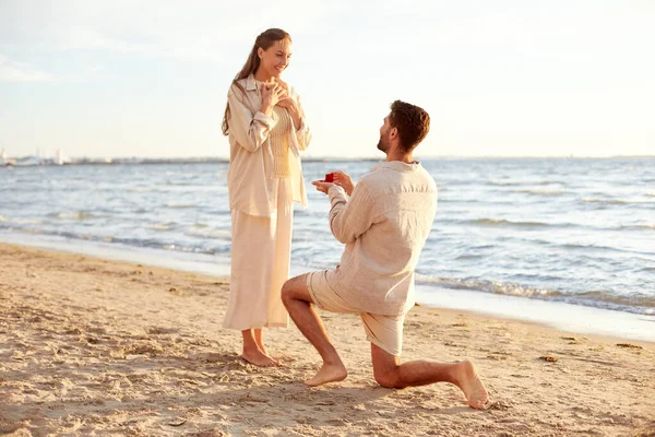 해변에서 여자에게 청혼을 하고 있는 남자 — 스톡 사진